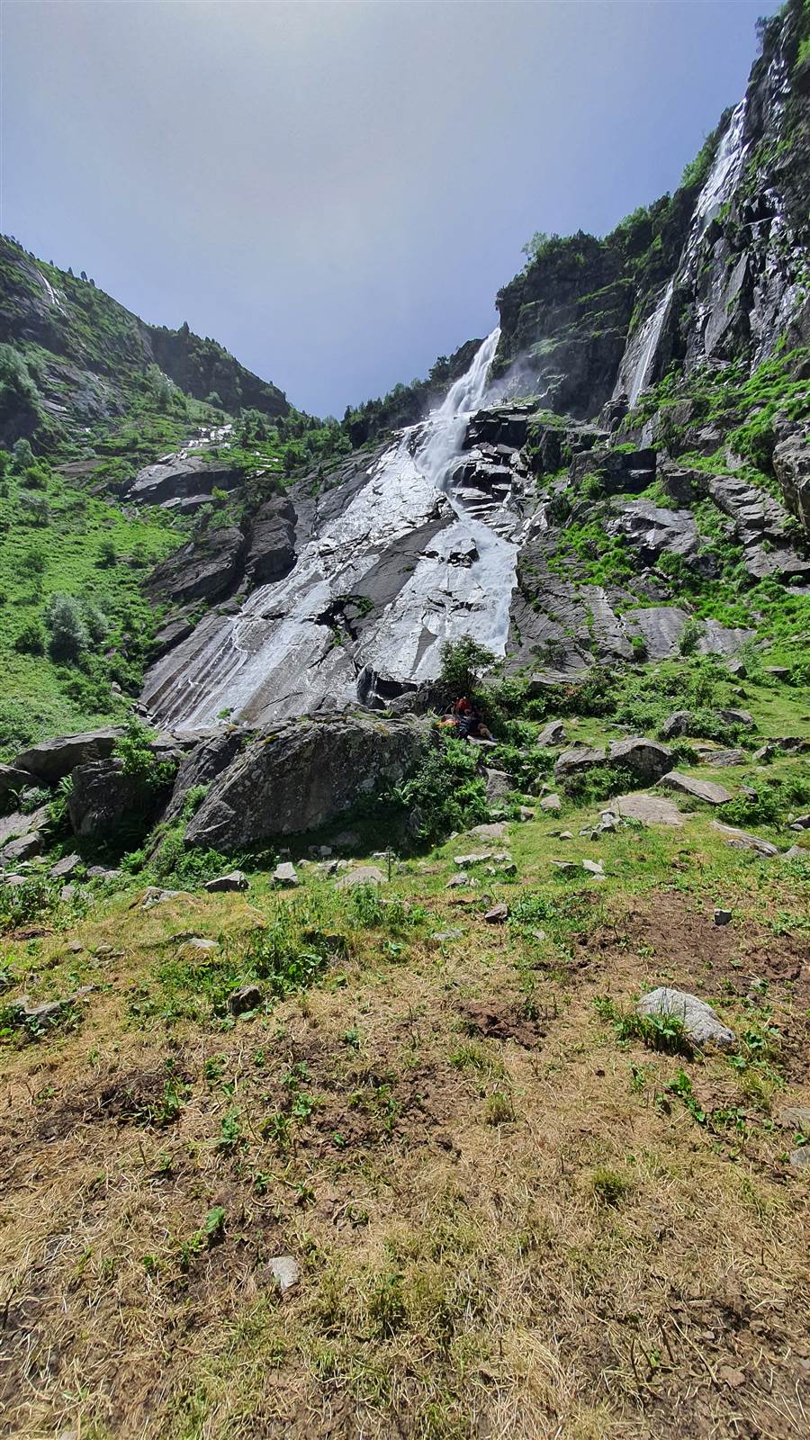 Un participant au pied de la cascade, immersion dans la montagne