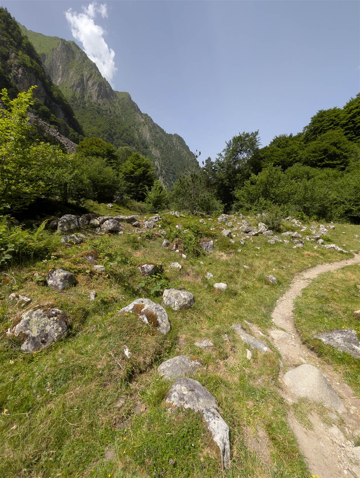 Le sentier serpente à travers la vallée, entouré de sommets